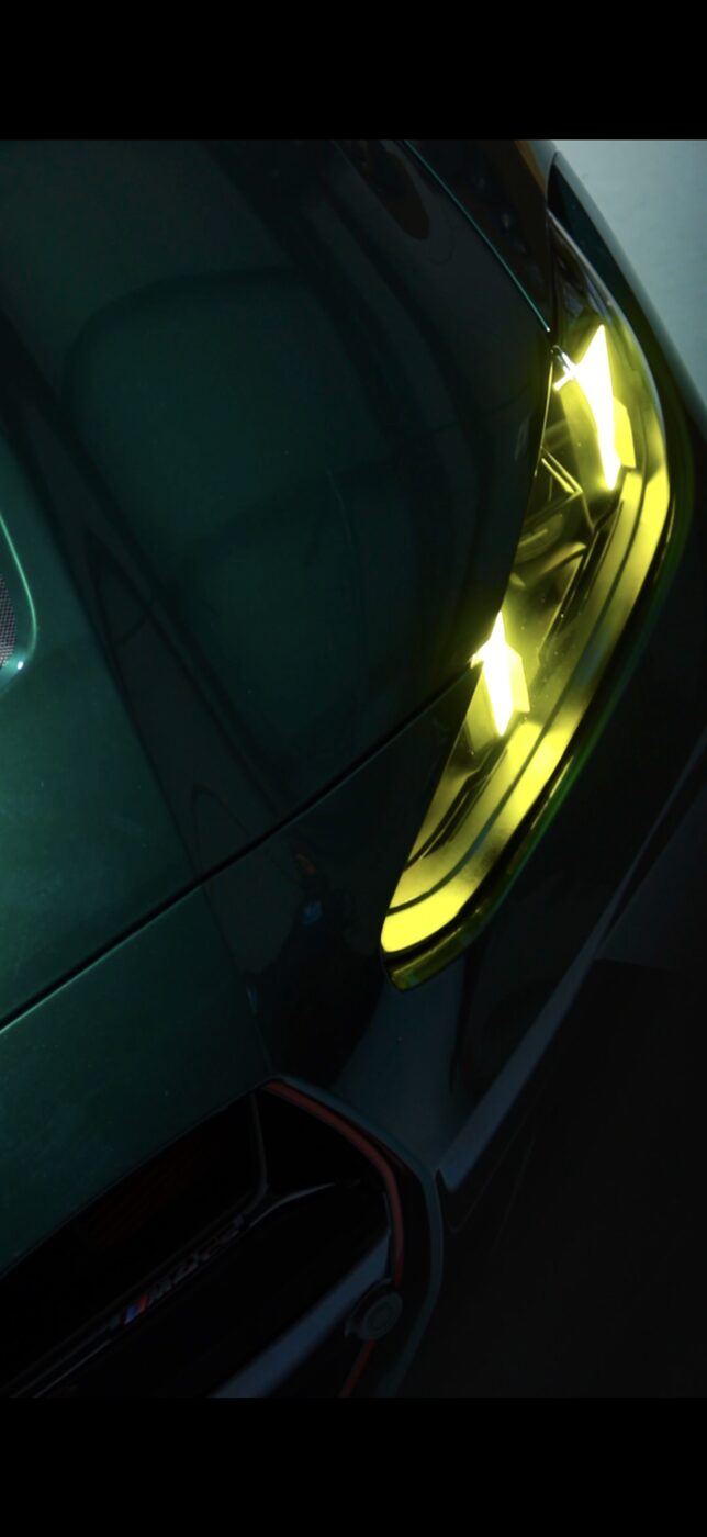Headlight detail on a dark green BMW M car