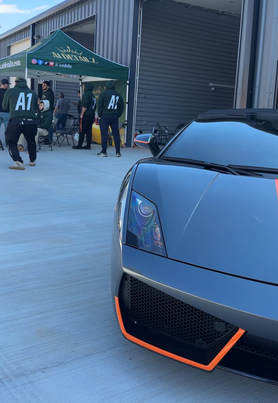 The A1 Detailz team in green hoodies beside a grey Lamborghini Gallardo