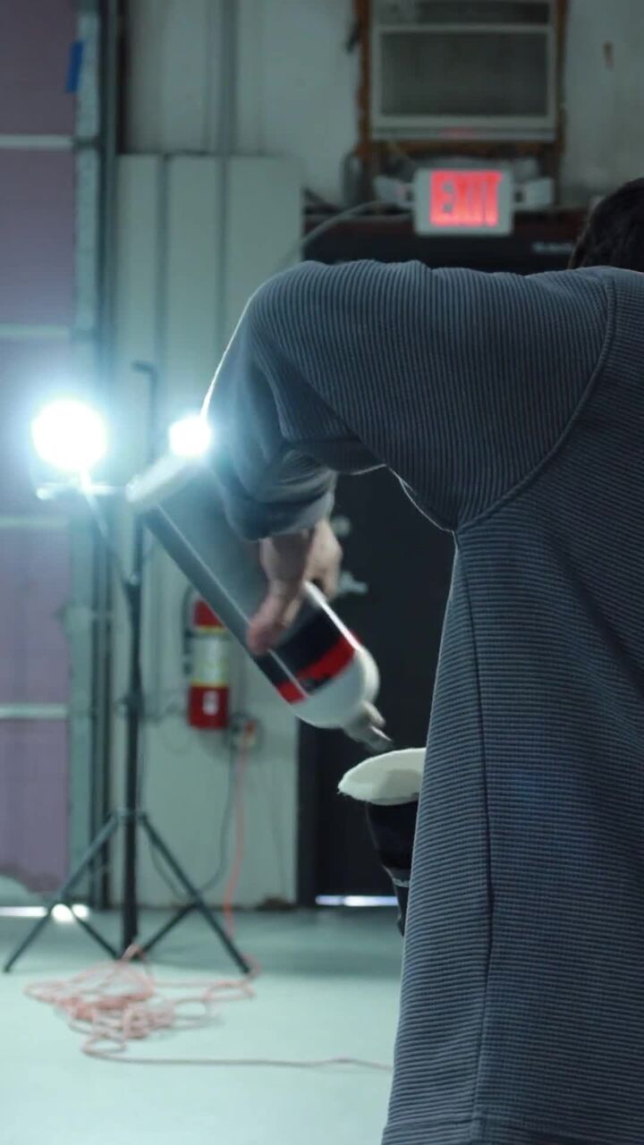 A detailer holding a foam-pad tool in a workshop